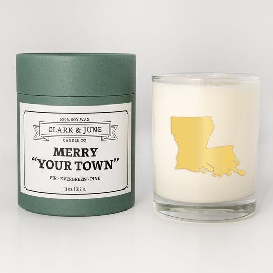 Double wicked soy candle in a 13.5 oz tumbler with the state of Louisianaprinted in 22k gold foil on the face. Green cylinder packaging with Merry "Your Town" on the label. SEO Text – Drinking glass, soy wax candle, Christmas Candle, hand poured, small batch, scented candle, Woman Owned, local candle, Housewarming present, gives back, charity, community candle, becomes a cocktail glass, closing gift. 