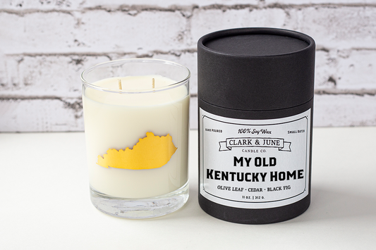 Double wicked soy candle in a 13.5 oz tumbler with the state of Kentucky printed in 22k gold foil on the face. Black cylinder packaging with “My Old Kentucky Home” on the label. SEO Text – Drinking glass, soy wax candle, Alabama candle, hand poured, small batch, scented candle, Woman Owned, local candle, Housewarming present, gives back, charity, community candle, becomes a cocktail glass, closing gift. 