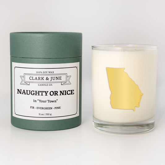 Double wicked soy candle in a 13.5 oz tumbler with the state of Georgiaprinted in 22k gold foil on the face. Green cylinder packaging with Naughty or Nice in "Your Town" on the label. SEO Text – Drinking glass, soy wax candle, Christmas Candle, hand poured, small batch, scented candle, Woman Owned, local candle, Housewarming present, gives back, charity, community candle, becomes a cocktail glass, closing gift. 