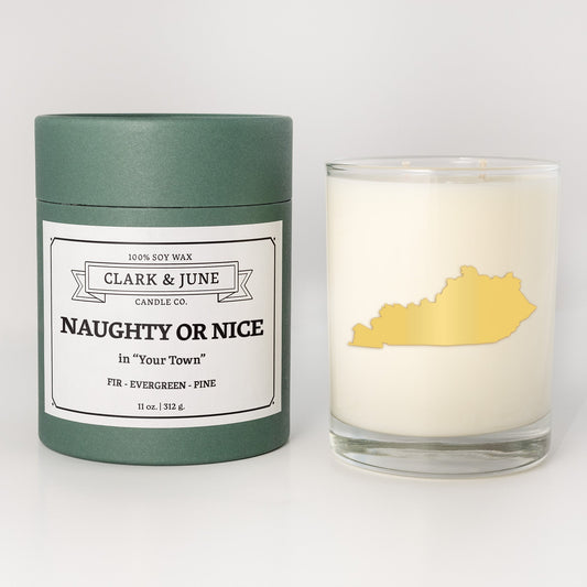 Double wicked soy candle in a 13.5 oz tumbler with the state of Kentuckyprinted in 22k gold foil on the face. Green cylinder packaging with Naughty or Nice in "Your Town" on the label. SEO Text – Drinking glass, soy wax candle, Christmas Candle, hand poured, small batch, scented candle, Woman Owned, local candle, Housewarming present, gives back, charity, community candle, becomes a cocktail glass, closing gift. 
