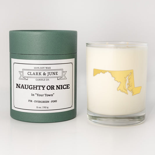 Double wicked soy candle in a 13.5 oz tumbler with the state of Marylandprinted in 22k gold foil on the face. Green cylinder packaging with Naughty or Nice in "Your Town" on the label. SEO Text – Drinking glass, soy wax candle, Christmas Candle, hand poured, small batch, scented candle, Woman Owned, local candle, Housewarming present, gives back, charity, community candle, becomes a cocktail glass, closing gift. 