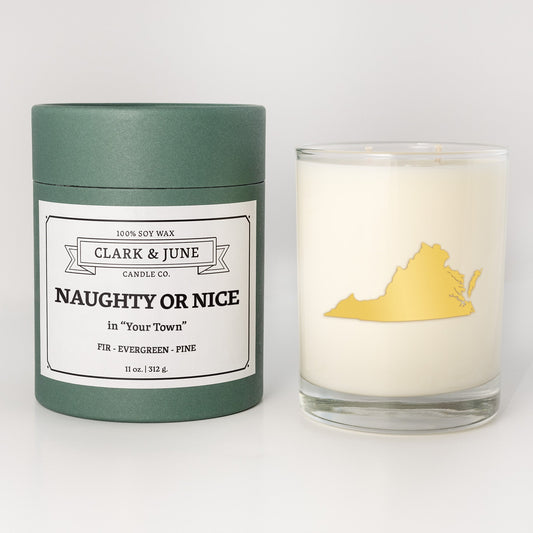 Double wicked soy candle in a 13.5 oz tumbler with the state of Virginiaprinted in 22k gold foil on the face. Green cylinder packaging with Naughty or Nice in "Your Town" on the label. SEO Text – Drinking glass, soy wax candle, Christmas Candle, hand poured, small batch, scented candle, Woman Owned, local candle, Housewarming present, gives back, charity, community candle, becomes a cocktail glass, closing gift. 
