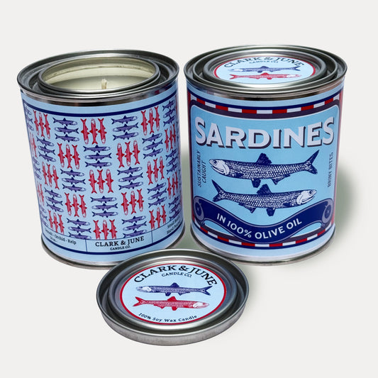 14oz Sardine design soy wax candle in a pint sized paint can made by Clark & June Candle Co. The candle is wrapped with a blue and red label showing a repeating pattern of blue and red sardines on the back and a recreation of a can of sardines in olive oil on the front. The scent is Seasalt – Orchid - Kelp and was hand poured in small batches. 

Sardine Candle, Scented Candle, Paint Can Candle. Single Cotton Wick, Fish Core
