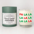 Load image into Gallery viewer, Double wicked soy candle in a 13.5 oz tumbler with Fa La La printed on the face. Green cylinder packaging with "Your Town" Christmas"on the label. SEO Text – Drinking glass, soy wax candle, Christmas Candle, hand poured, small batch, scented candle, Woman Owned, local candle, Housewarming present, gives back, charity, community candle, becomes a cocktail glass, closing gift. 
