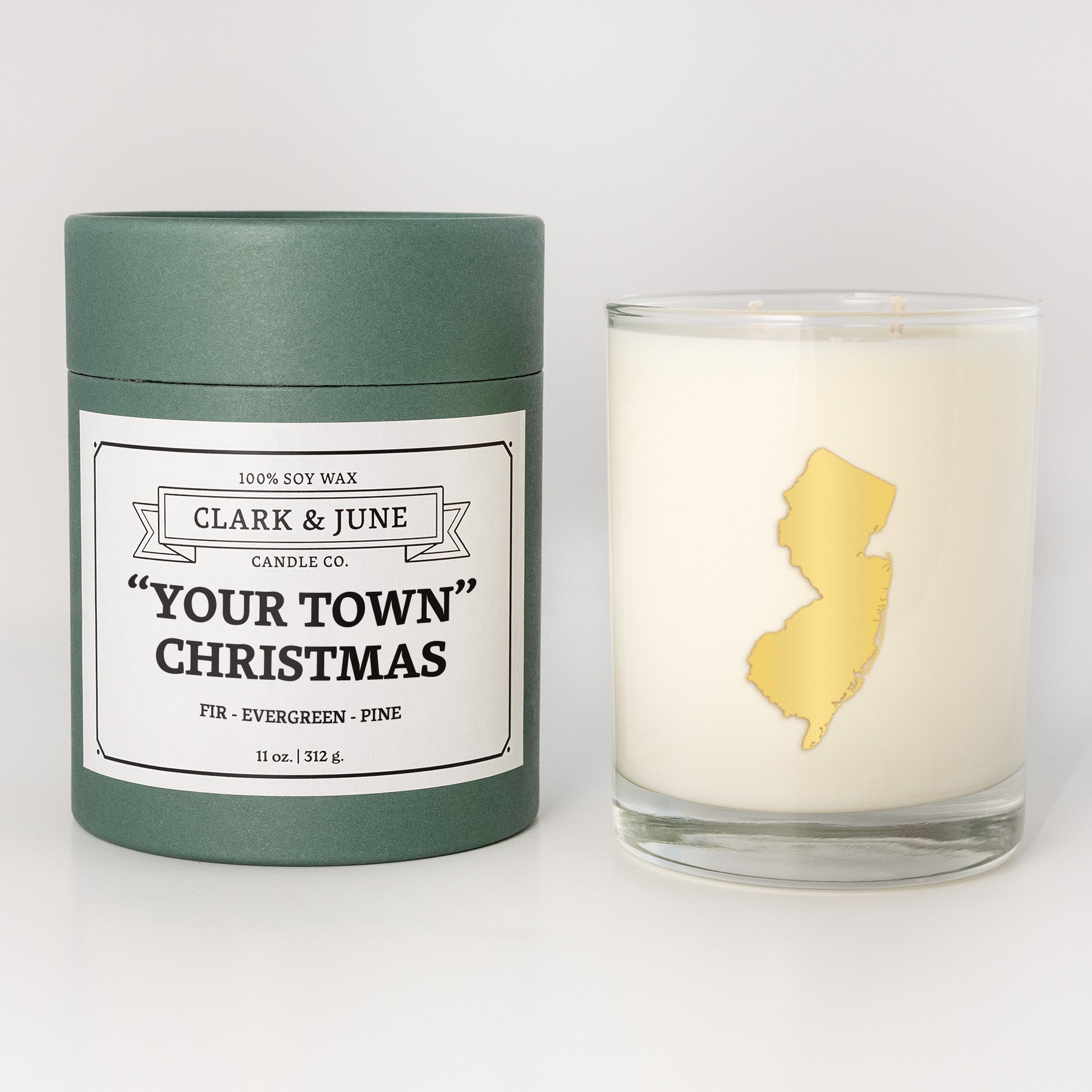 Double wicked soy candle in a 13.5 oz tumbler with the state of New Jerseyprinted in 22k gold foil on the face. Green cylinder packaging with "Your Town" Christmas on the label. SEO Text – Drinking glass, soy wax candle, Christmas Candle, hand poured, small batch, scented candle, Woman Owned, local candle, Housewarming present, gives back, charity, community candle, becomes a cocktail glass, closing gift. 